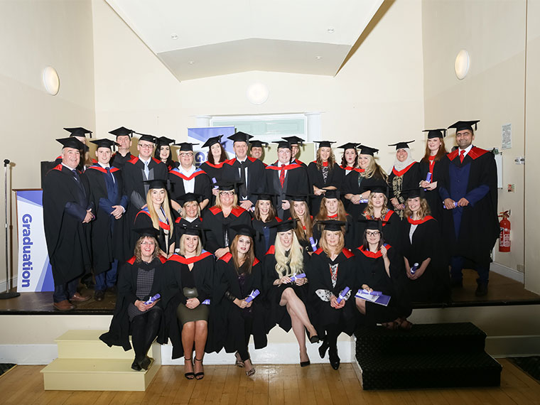 More than thirty Higher Education students donning gowns and mortar boards to receive their awards from John Connolly, Chief Executive of RNN Group