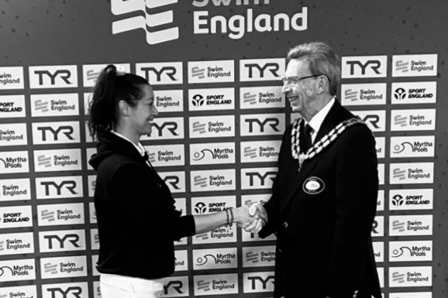 Elizabeth Bird shaking hands with a mayoral official while at an event for Swim England.
