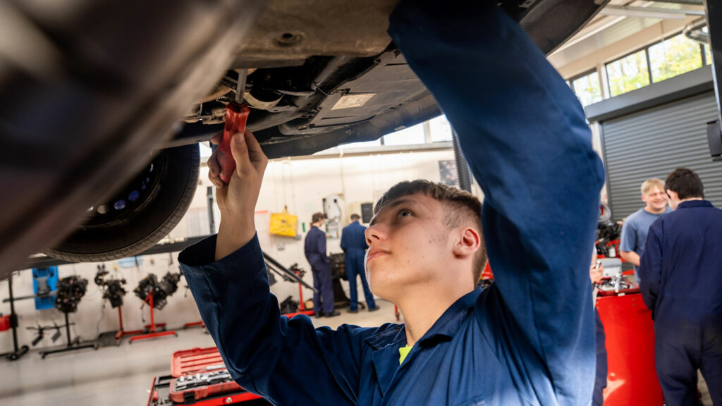 A motor vehicle student working on a car