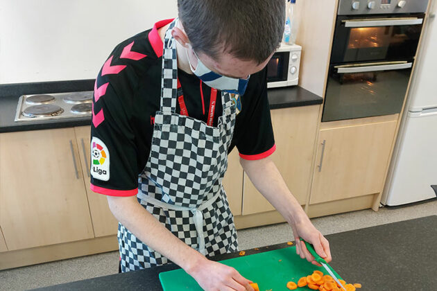 Flex student chopping carrots.