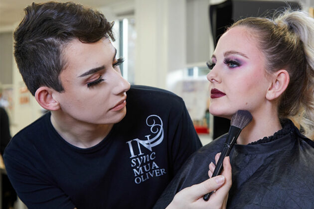 Oliver Helm applying make-up to a model.
