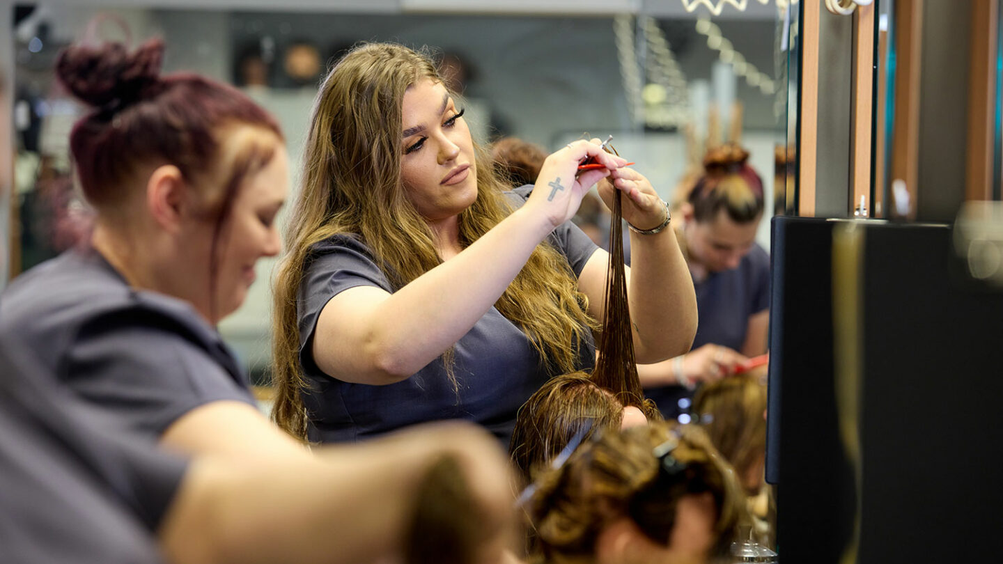 A hairdressing student working on a client's hair