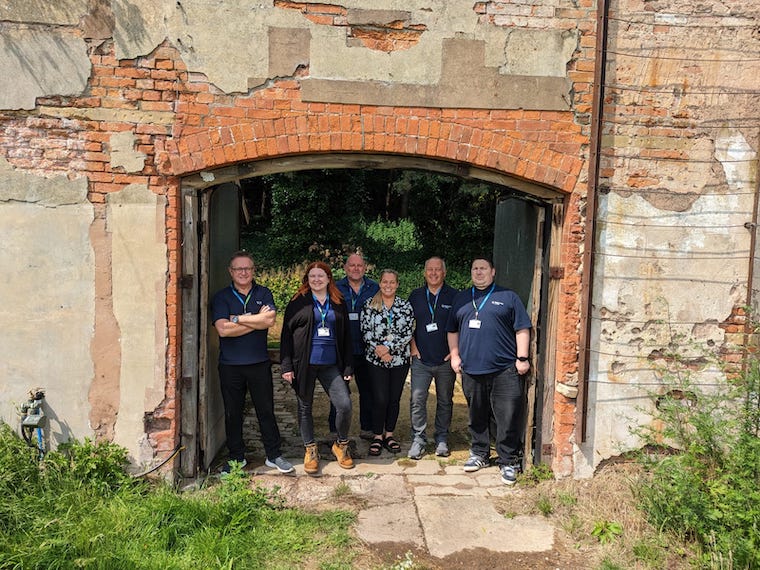 Staff members stood in the Gateway at the walled garden.